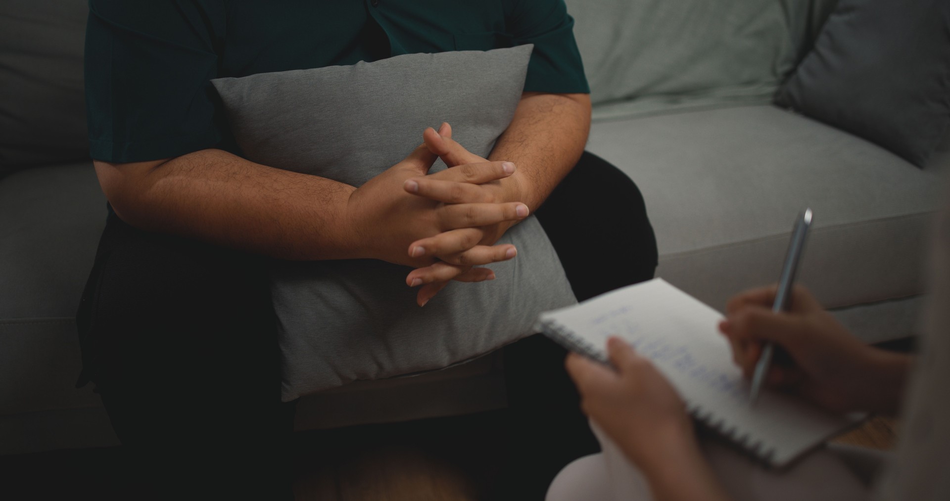 Asian therapists writing down notes during therapy with male patients