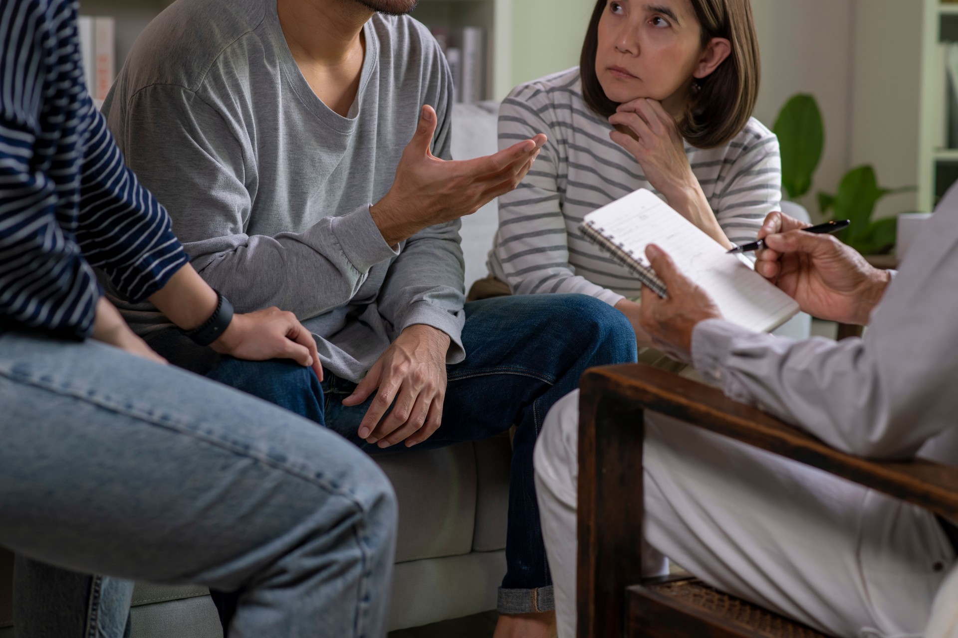 Therapist, psychologist talking to and counselling people in group therapy